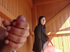 A young man surprises a Muslim girl at the bus stop with his large penis, causing her shock and potential trouble